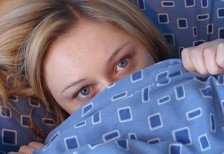 vrouw met gezicht onder dekbed