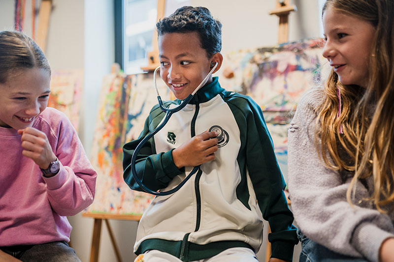 Kinderlongarts E. Kersten geeft les aan basisschool kinderen