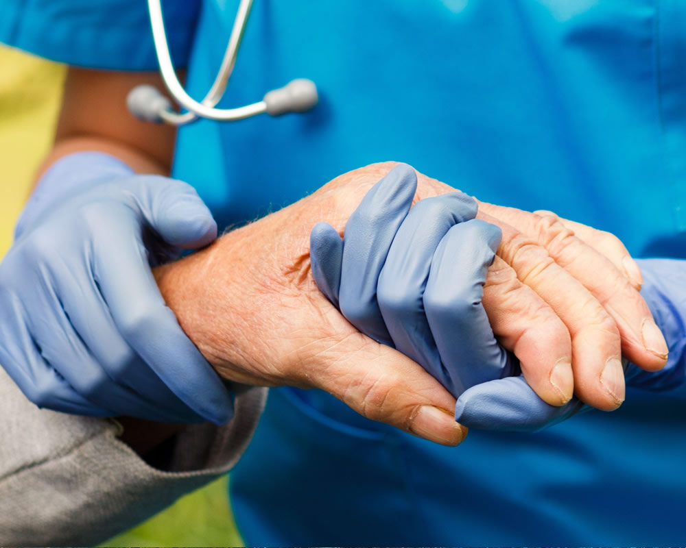 zorgverlener houdt hand van patient vast