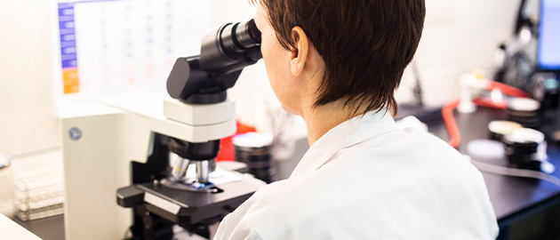 Mens achter microscoop