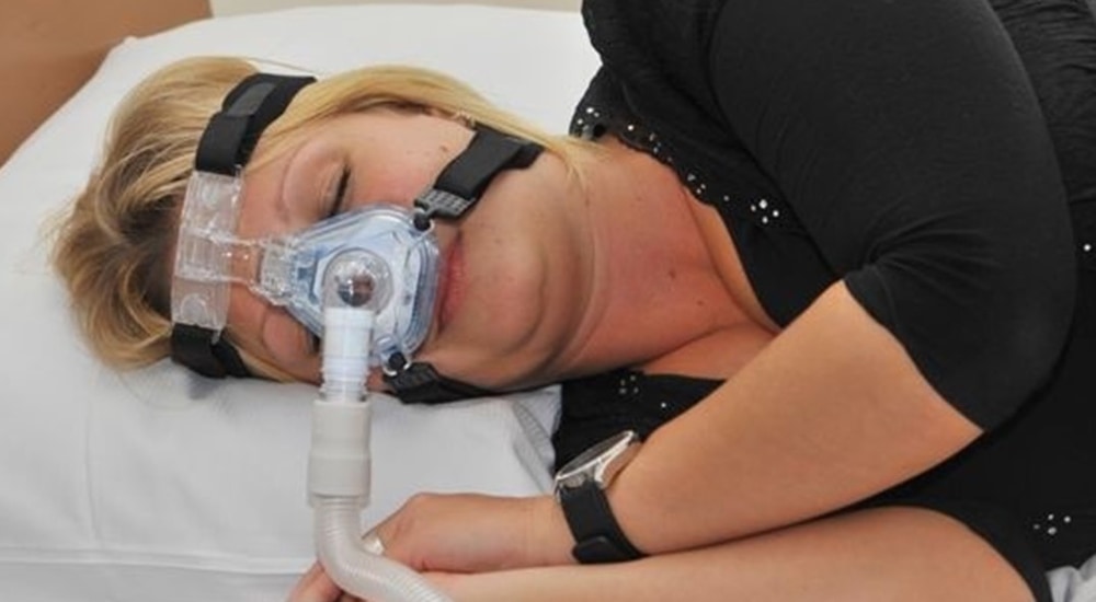 Vrouw ligt aan de beademing in bed